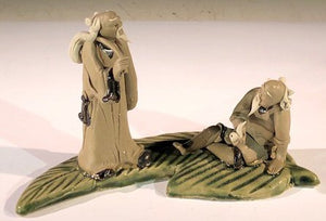 Miniature Ceramic Figurine <br>Two Mud Men On A Leaf, One Standing holding a bag, The Other Sitting Smoking a Pipe- 3"