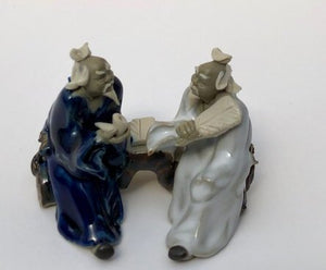 Ceramic Figurine<br>Two Men Sitting On A Bench Holding Fan & Pipe- 2.25"<br>Color: Blue & White